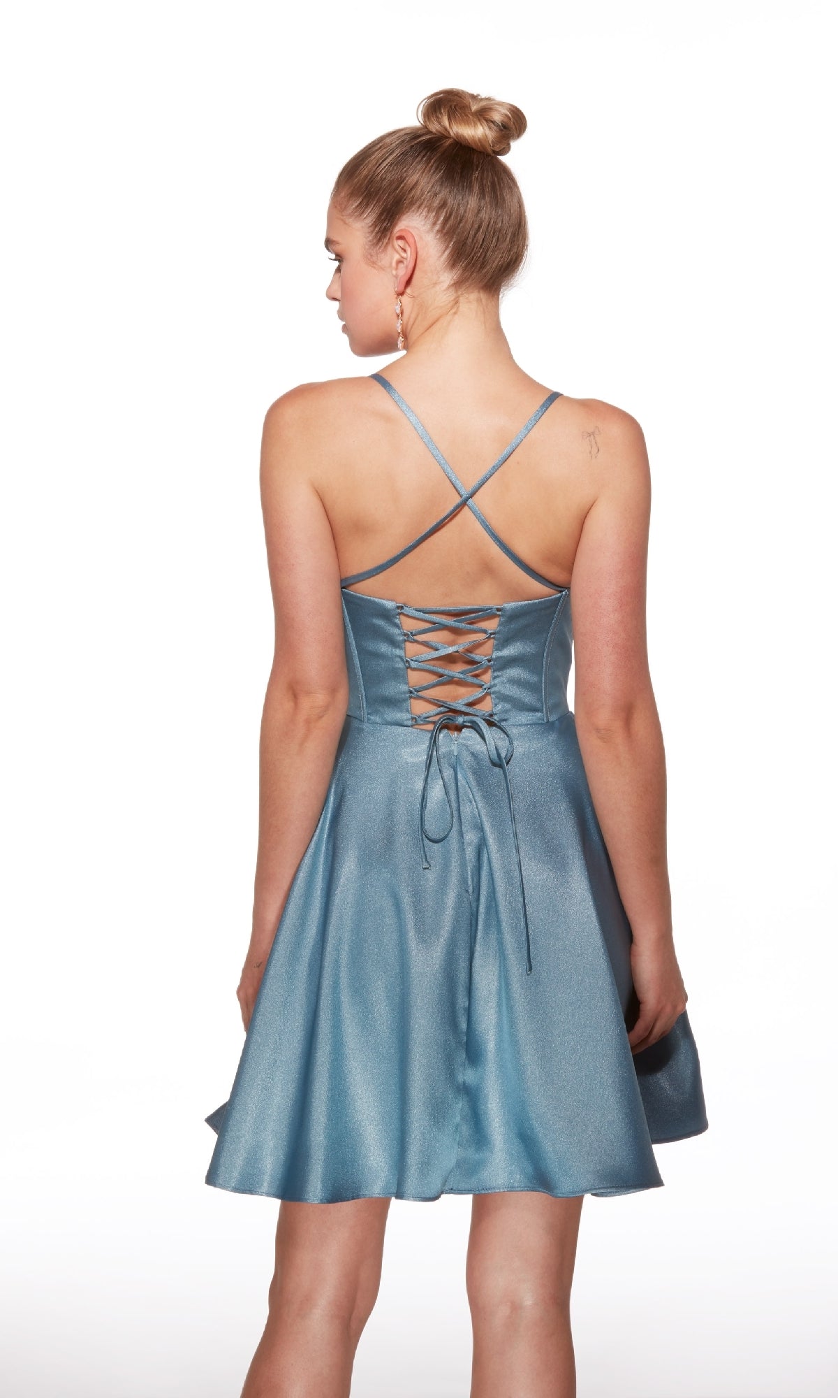 A woman faces away from the camera against a white background, wearing the Alyce 30047 short homecoming dress in light blue satin with a fit-and-flare silhouette, crisscross straps, and a lace-up open back.